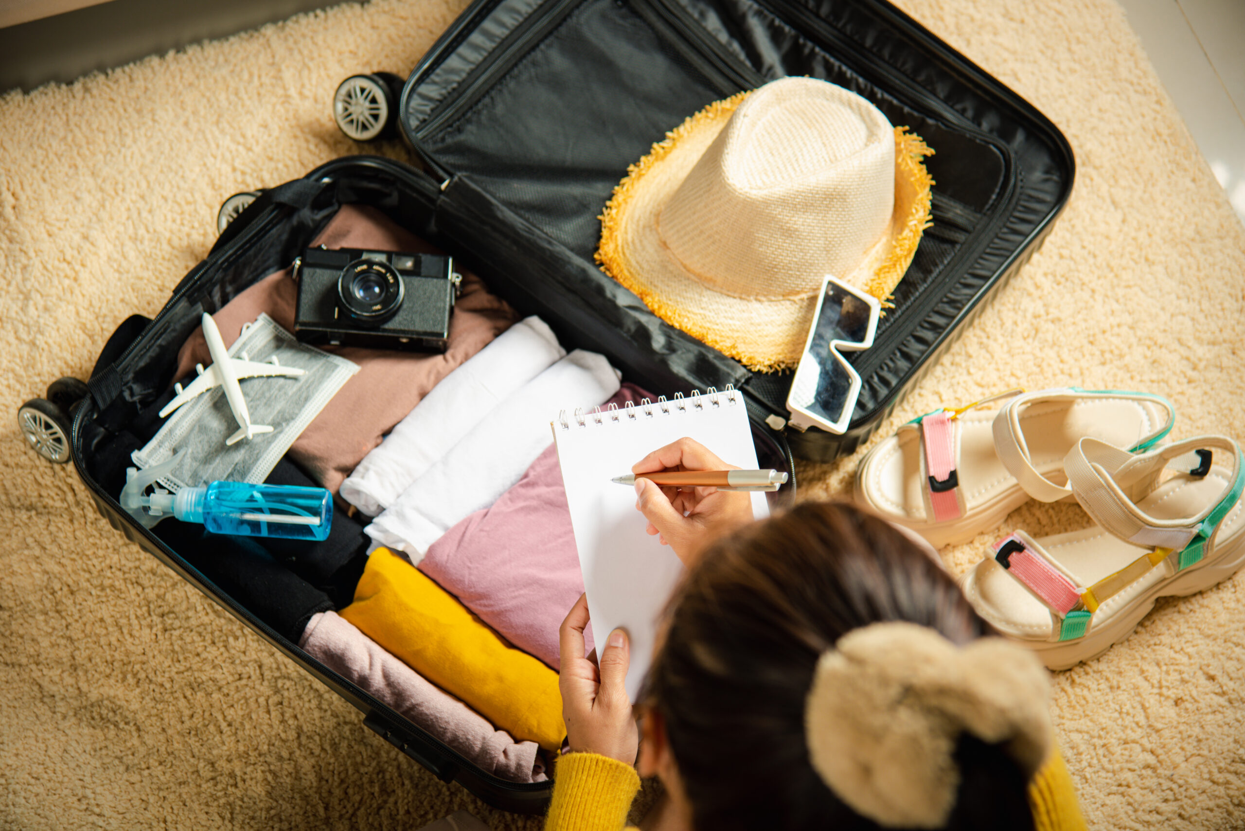 Packing List for Your River Cruise: Essentials, Tips, and Tricks - Woman Crossing Items Off Packing List While Packing Suitcase